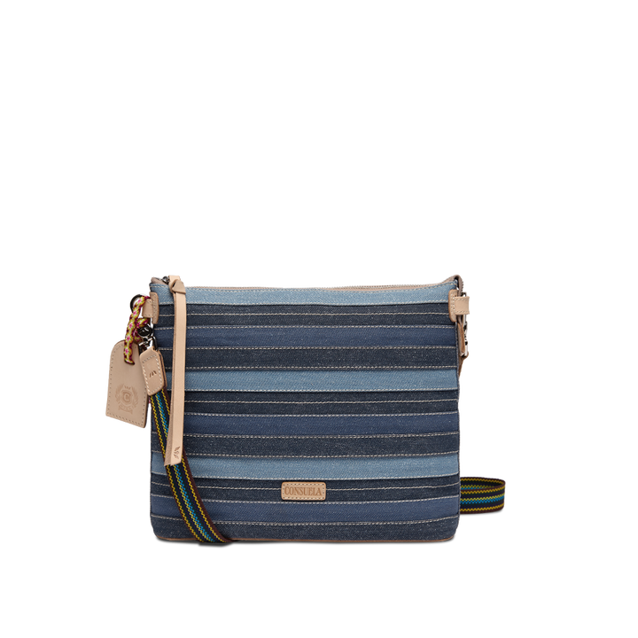 Consuela Royal Downtown Crossbody in denim-inspired blue stripes, front view with a colorful woven strap draped to the side.