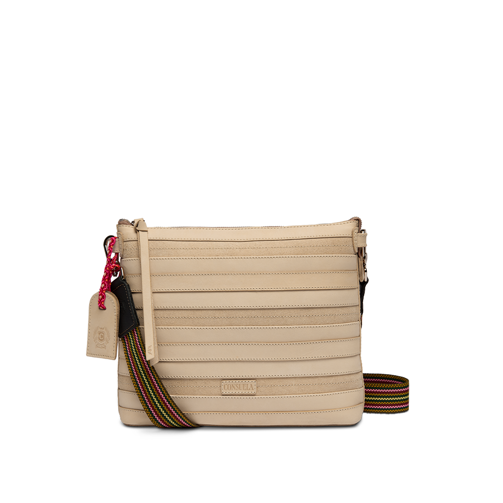 Consuela Amina Downtown Crossbody in natural ribbed leather, front view with an adjustable rainbow strap draped to the side.