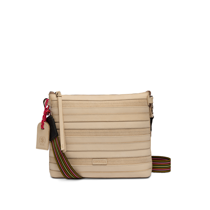 Consuela Amina Downtown Crossbody in natural ribbed leather, front view with an adjustable rainbow strap draped to the side.