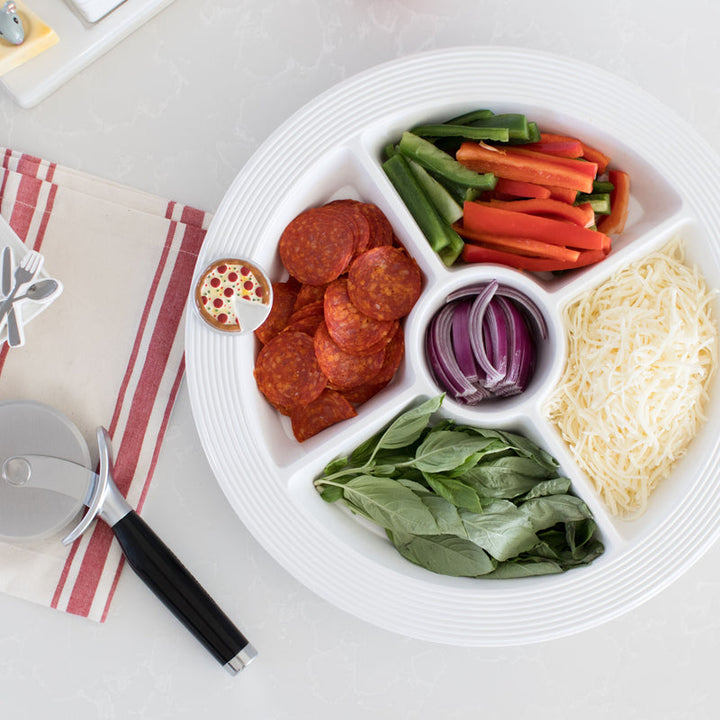 Nora Fleming Slice, Slice, Baby! pizza mini attached to a pinstriped divided serving dish filled with food.
