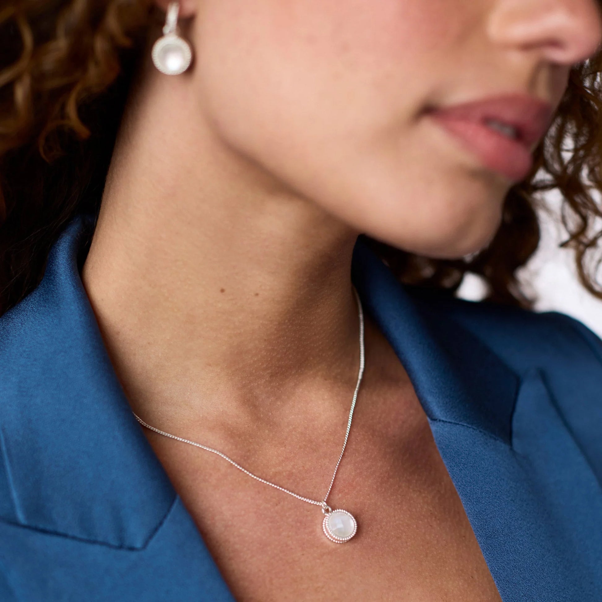 Model wearing the Fleur-de-Lis Solitaire Necklace to demonstrate the adjustable 17/18-inch length and scale.