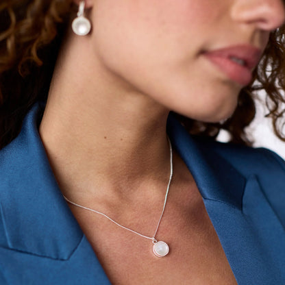 Model wearing the Fleur-de-Lis Solitaire Necklace to demonstrate the adjustable 17/18-inch length and scale.