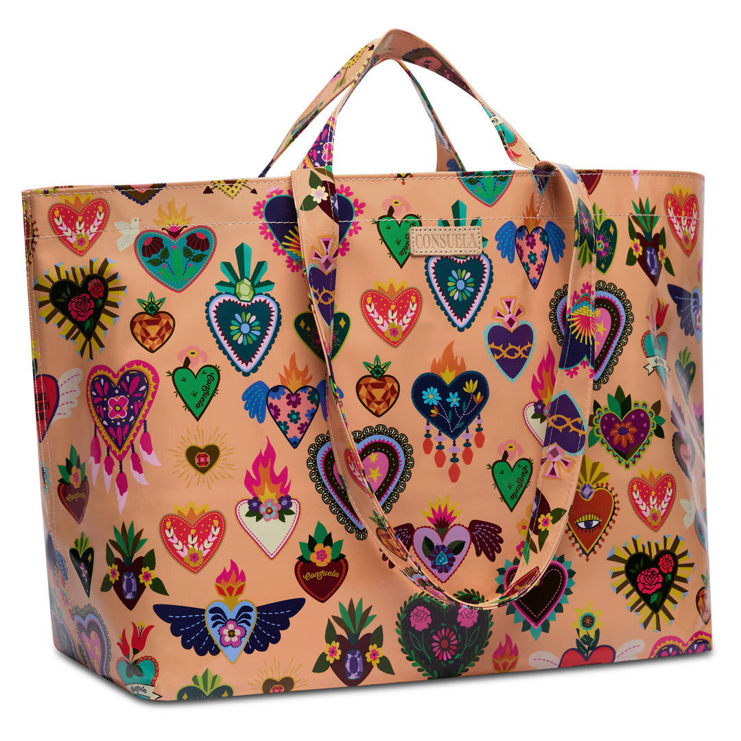 Three-quarter angled view of the Consuela Peach Grab n Go Jumbo, highlighting the roomy side depth and all-over multi-color heart-and-floral print.