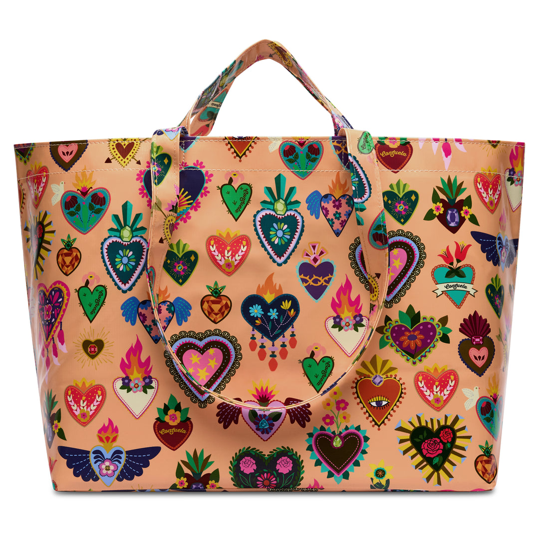 Consuela Peach Grab n Go Jumbo oversized tote in glossy peach, front view covered with a colorful folk-art sacred-heart and floral print and dual top handles.