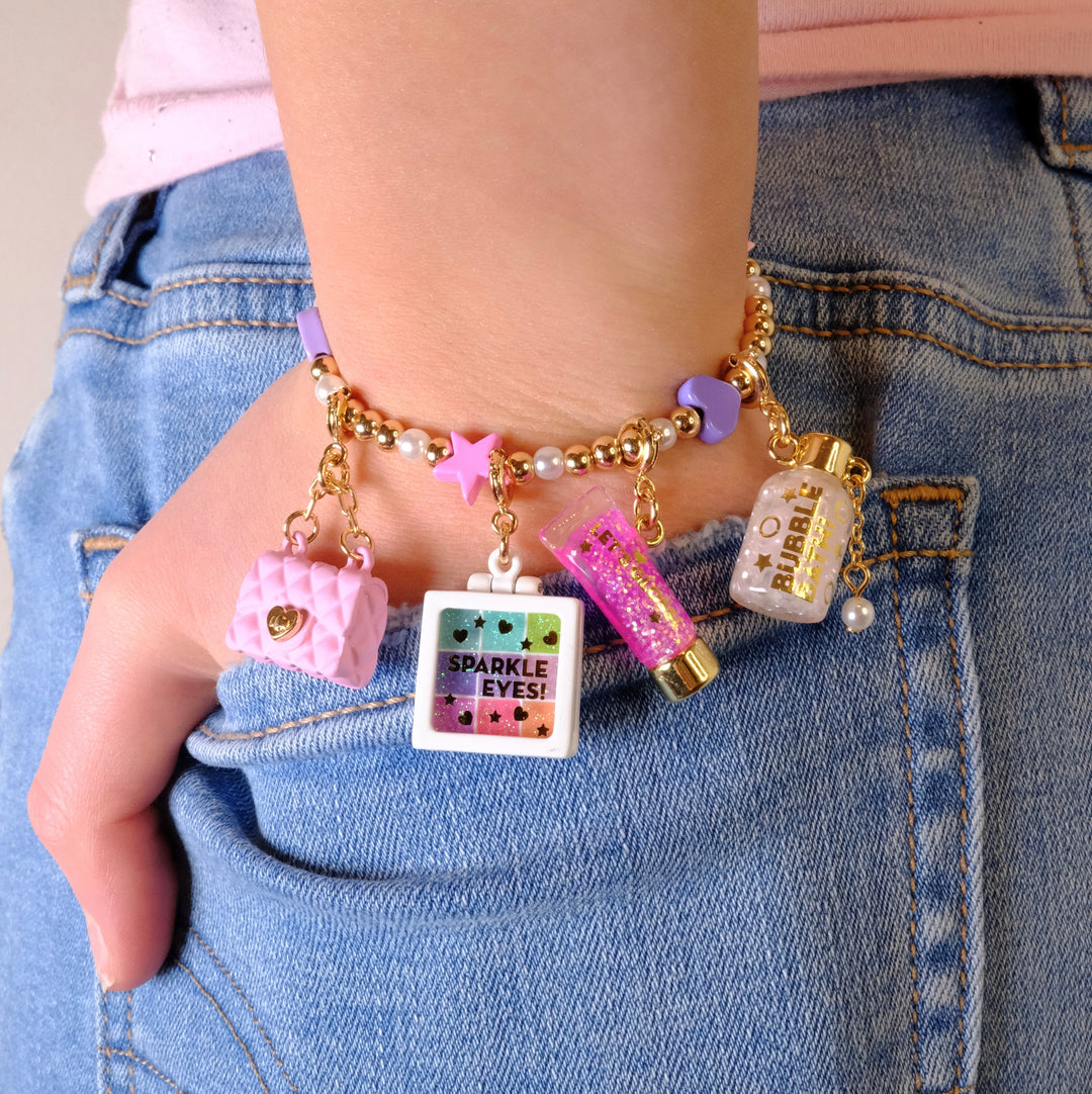 Charm It Gold Pink Purse charm on a glam charm bracelet with makeup charms