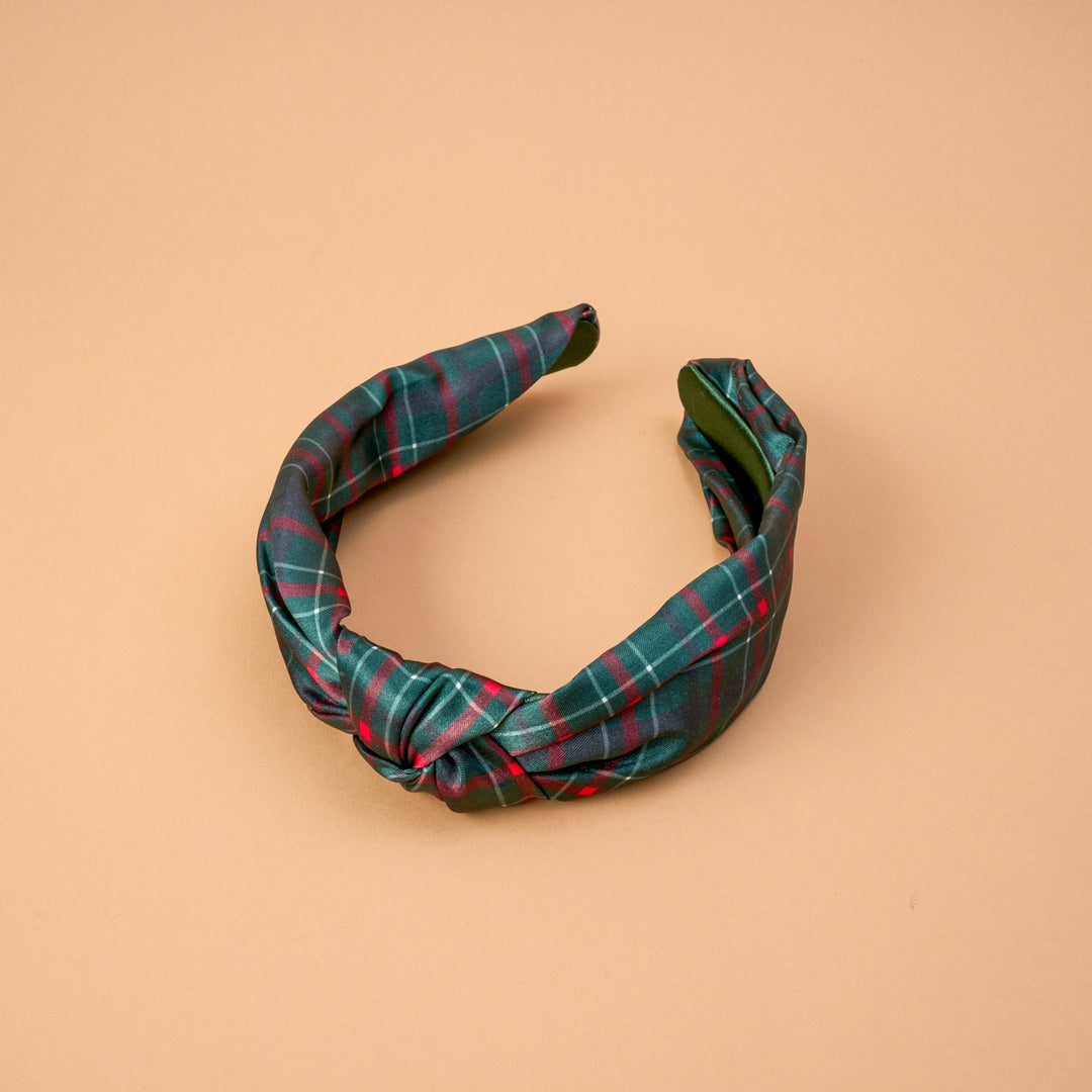 The Darling Effect Classic Twist Headband featuring a festive dark green Evergreen Plaid pattern.