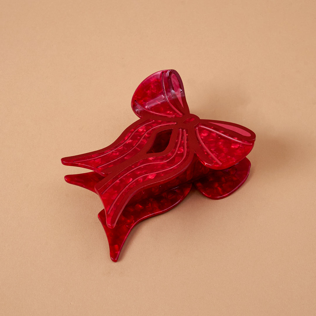 The Darling Effect Shape Up Claw Clip in a festive red bow design.