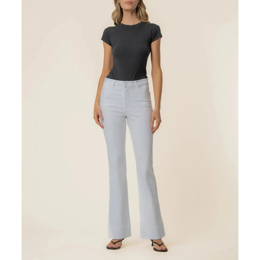 Woman wearing Kut from the Kloth Stella high-rise flare jeans in optic white with back darts and a wide hem.