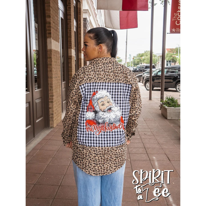 Model turned away showing the back of the Spirit to a Tee animal print holiday flannel featuring a large vintage smiley Santa patch.