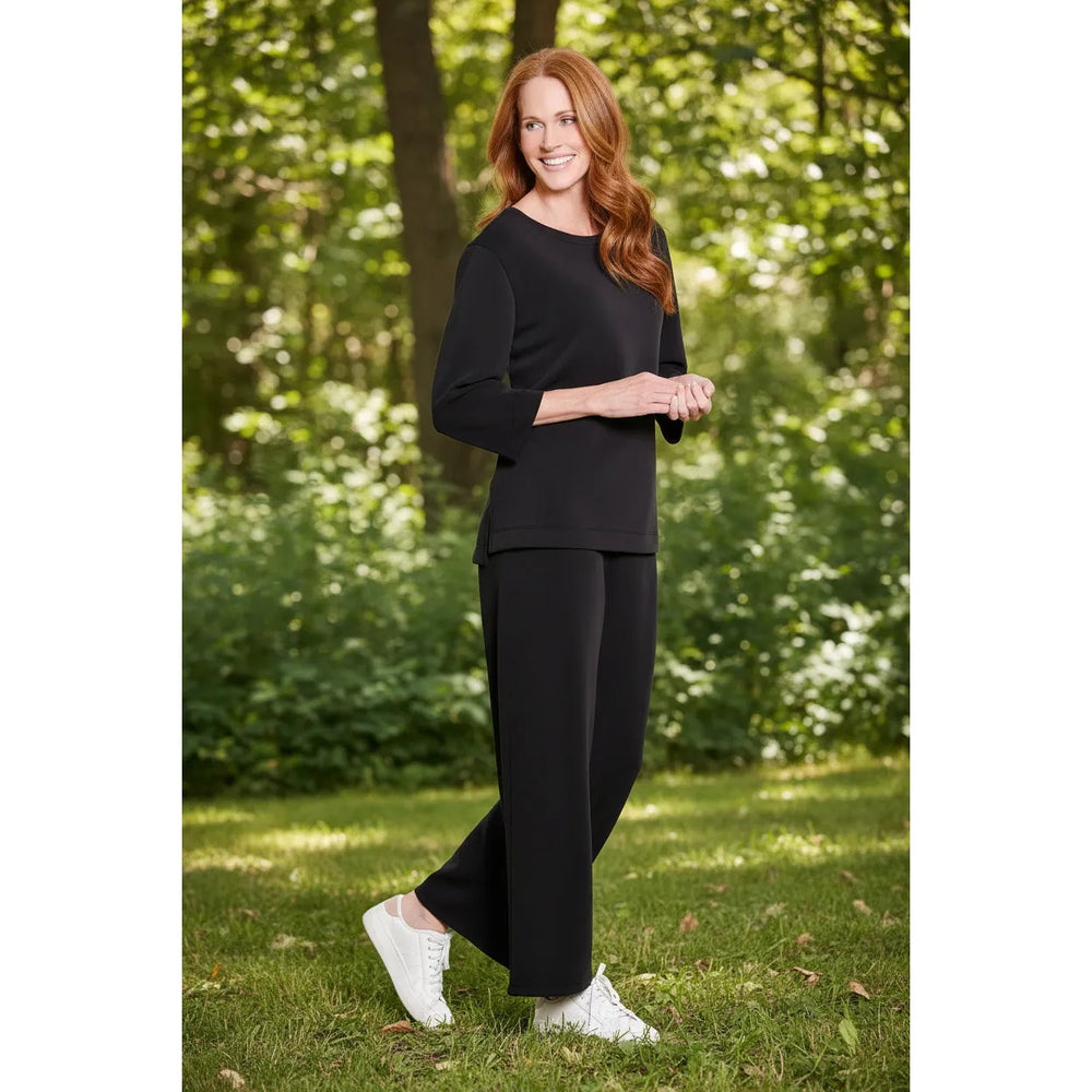 Multiples two-piece black knit set featuring a drop shoulder hi-low top and wide-leg ankle pants.