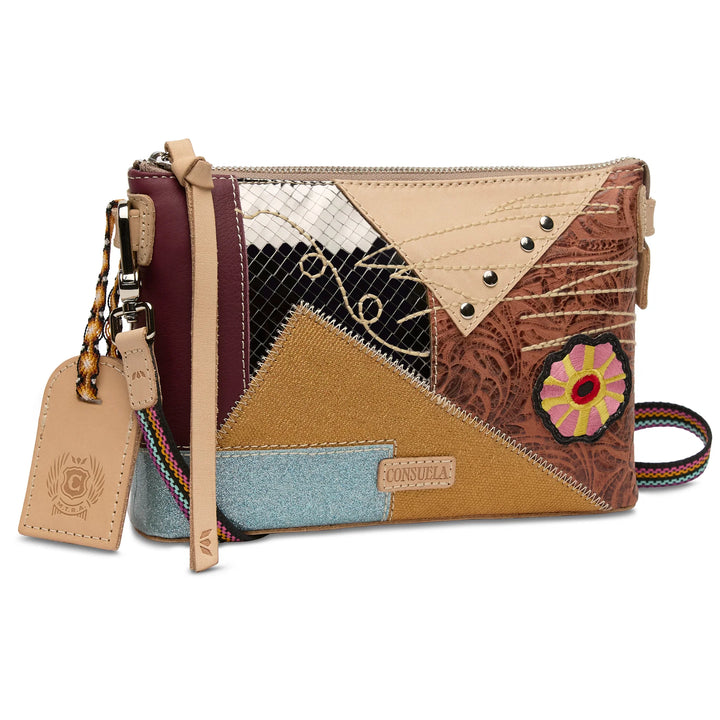Angled view of the Consuela Max Midtown Crossbody showing the leather hang tag and colorful woven strap