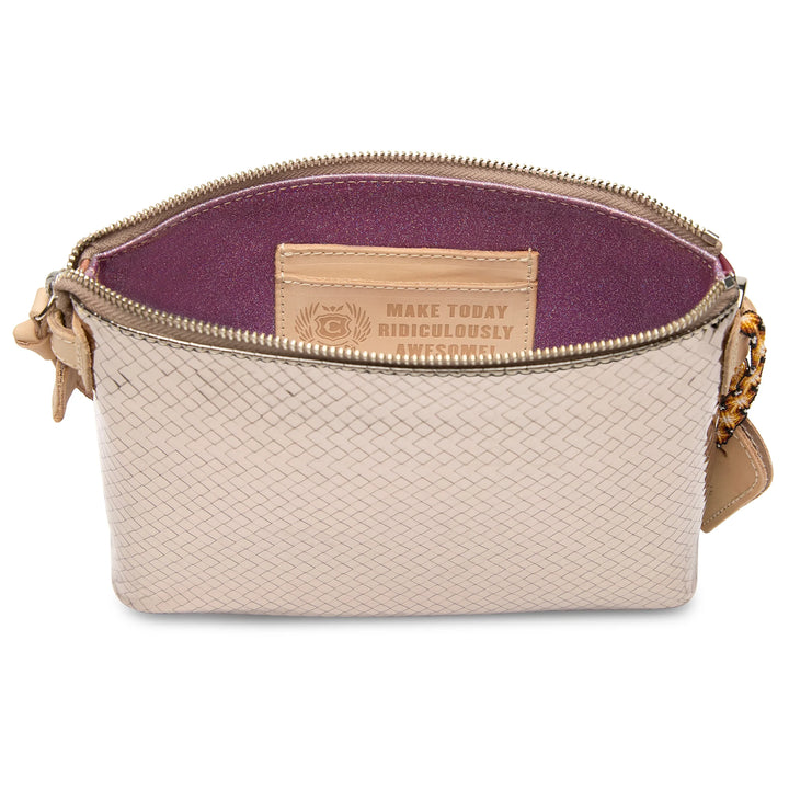 Open Consuela Max Midtown Crossbody showing the purple interior lining and leather inside label