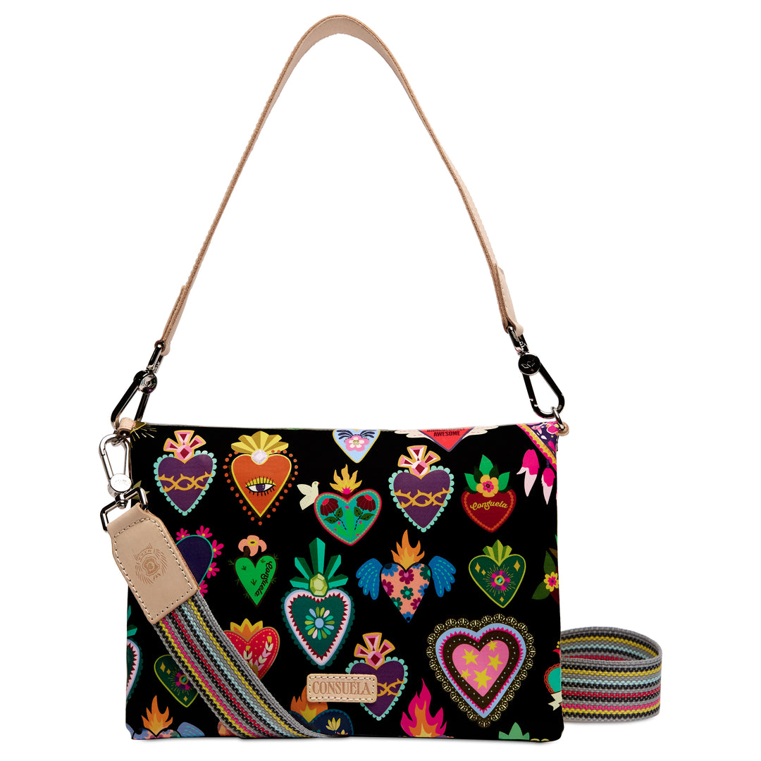Consuela Vida Metro Crossbody, front view — colorful heart print on black with tan leather handle and woven crossbody strap