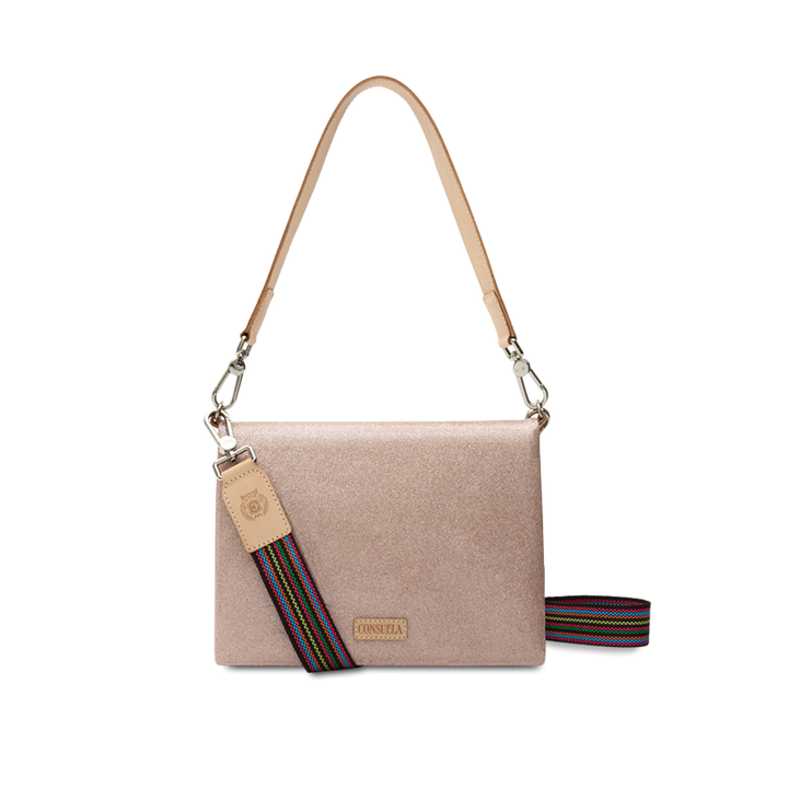 Consuela Emery Metro Crossbody in blush metallic glitter, front view with a natural leather strap and rainbow woven crossbody strap on a light background.