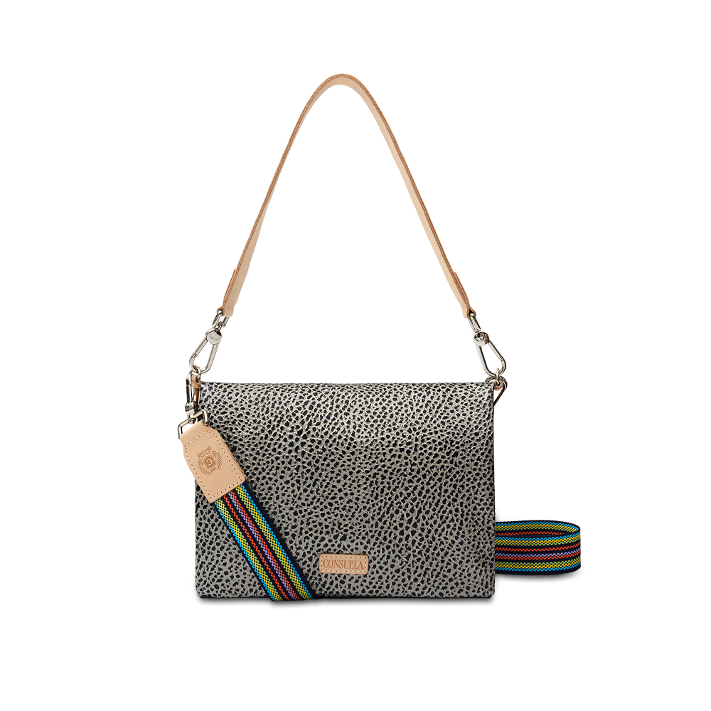 Consuela Tommy Metro Crossbody, front view — gray and black pebble print with tan leather handle and rainbow-striped woven strap