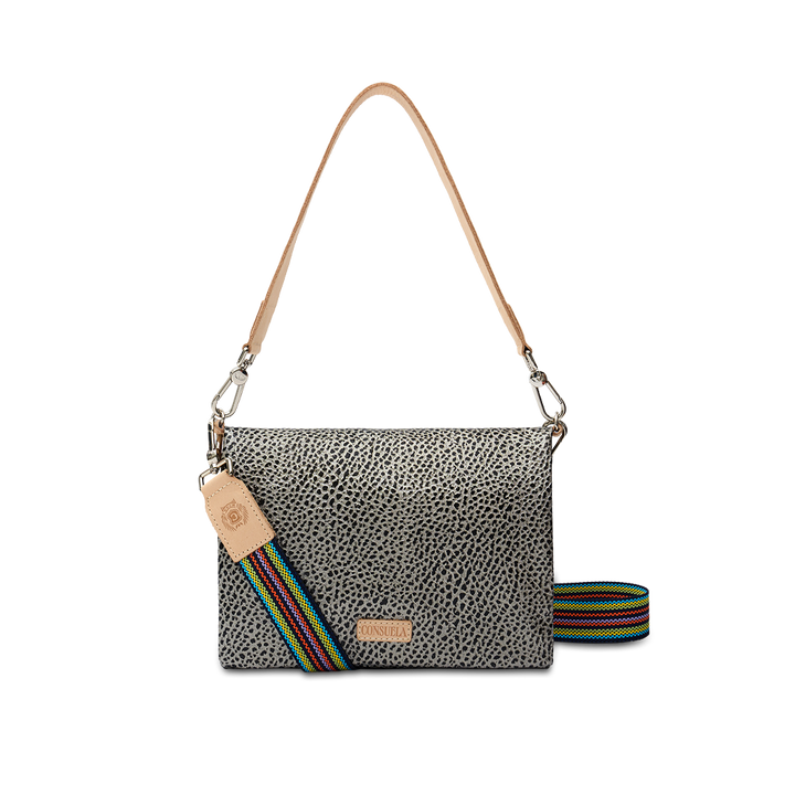 Consuela Tommy Metro Crossbody, front view — gray and black pebble print with tan leather handle and rainbow-striped woven strap