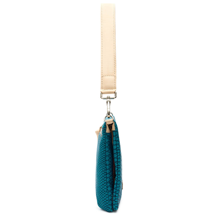 Side profile of the Consuela Indy Metro Crossbody showing its slim depth and natural leather strap.
