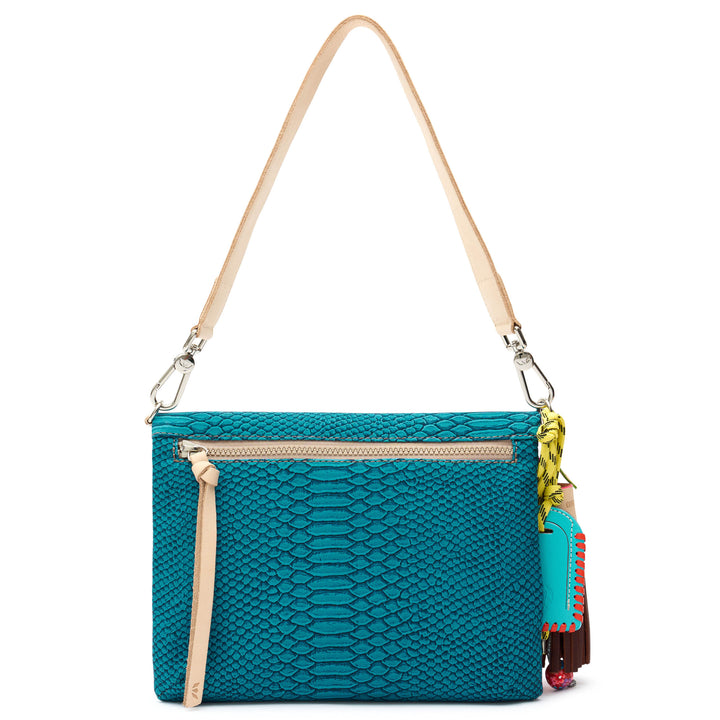 Back view of the Consuela Indy Metro Crossbody showing the teal reptile-embossed leather and an exterior back zip pocket.