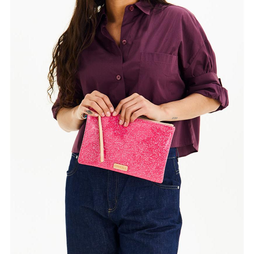 Consuela Bae Mighty Pouch featuring a bright multicolored glitter exterior and natural leather zipper pull.