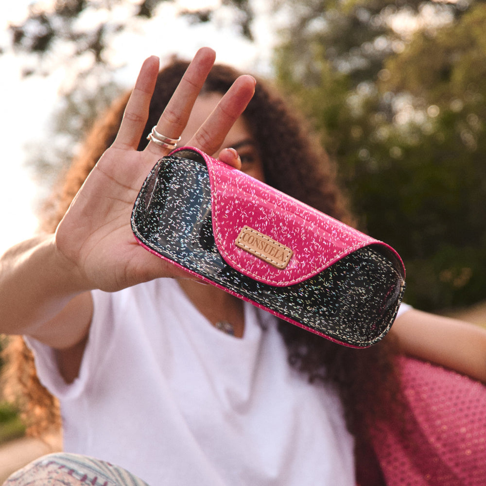 Consuela Bae Sunglass Case featuring a multicolored glitter exterior and natural leather logo patch.