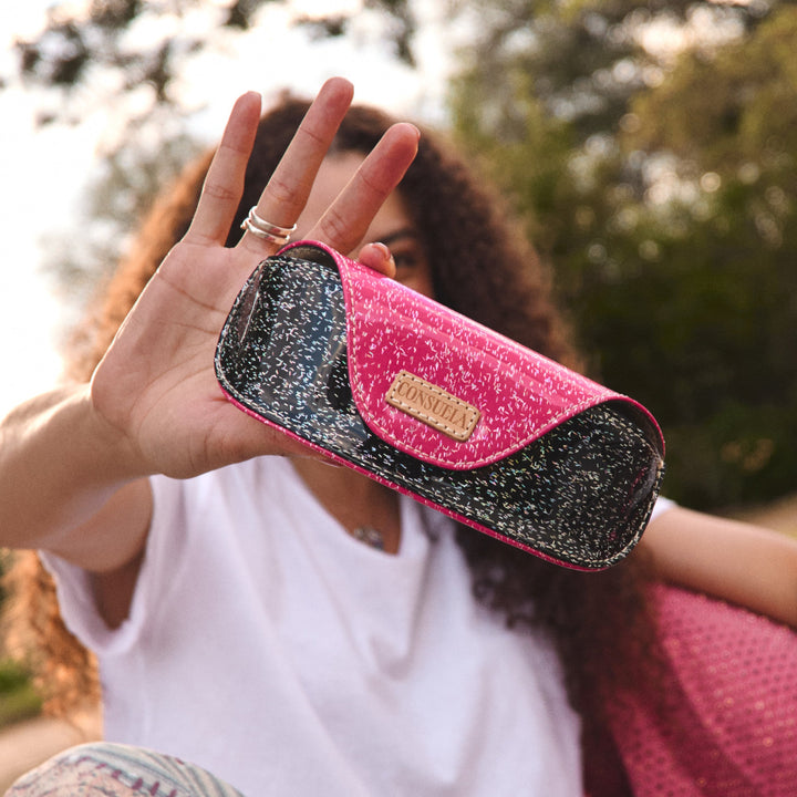 Consuela Bae Sunglass Case featuring a multicolored glitter exterior and natural leather logo patch.