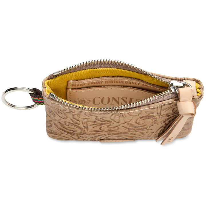 consuela Lawton pouch leather, with a silver zipper, shown open to reveal a yellow interior lining and a branded card slot. A metal key ring is attached on the left, and a tan leather pull tab hangs from the zipper on the right.
