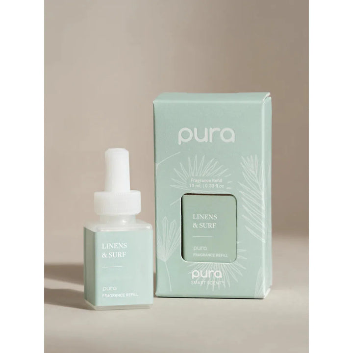 Pura smart fragrance vial in Linens &amp; Surf, featuring a clean white label with blue and grey wave-inspired sketches.