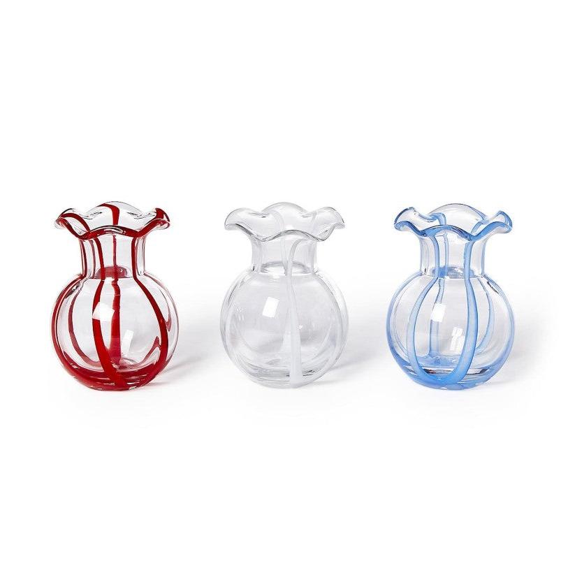 Three glass vases in red, clear, and blue on a white background