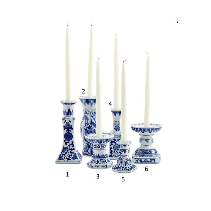 Set of six blue and white candle holders with candles on a white background