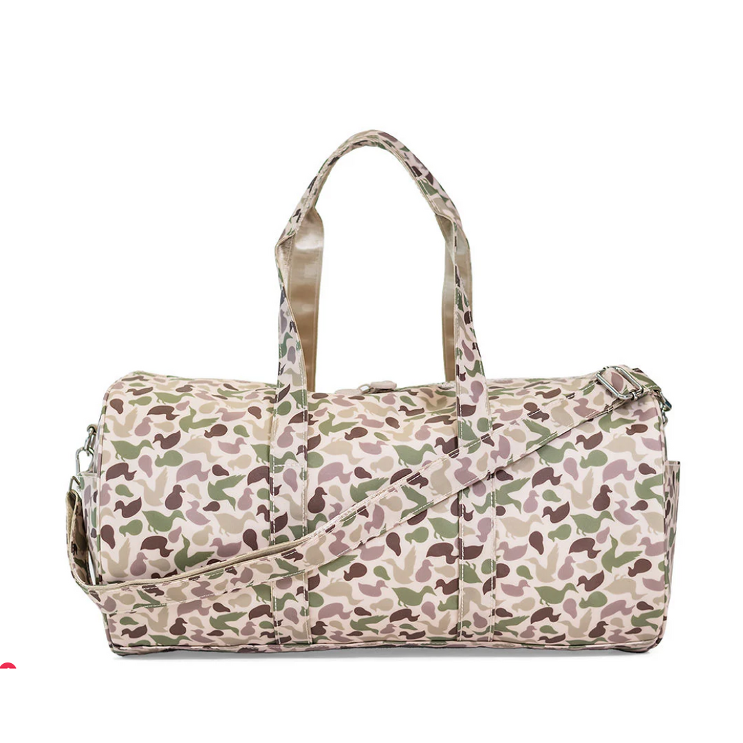TRVL Design Large Roll Duffel in green Decoy camo; water-resistant travel bag with white chunky zipper and shoulder strap.