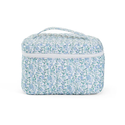 Quilted blue and white floral cosmetic train case with a white zipper and top handle.