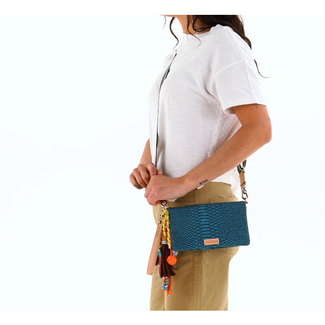 Consuela Indy Uptown Crossbody bag featuring a turquoise reptile-inspired textured exterior and a woven strap.