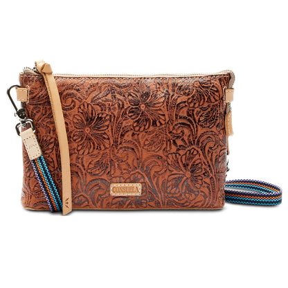 Consuela Sally Midtown Crossbody with floral print, tooled leather trim, and adjustable woven strap.