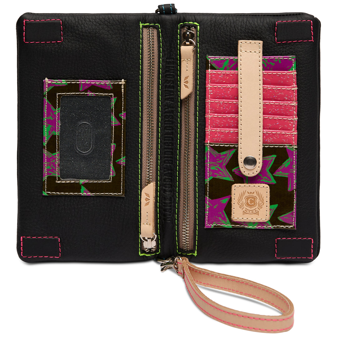 Interior of the Consuela Cyndi Uptown Crossbody with magenta-and-green star-print lining, card slots, a clear ID window and zip pockets
