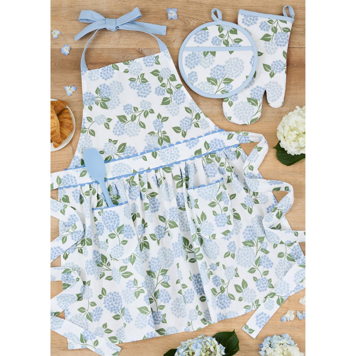 Folded Hydrangea Garden apron paired with matching floral tea towels, tied with a ribbon as a kitchen gift set.