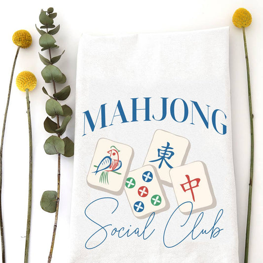 White cotton flour sack tea towel featuring a colorful "Mahjong Social Club" design with traditional tiles and elegant script.