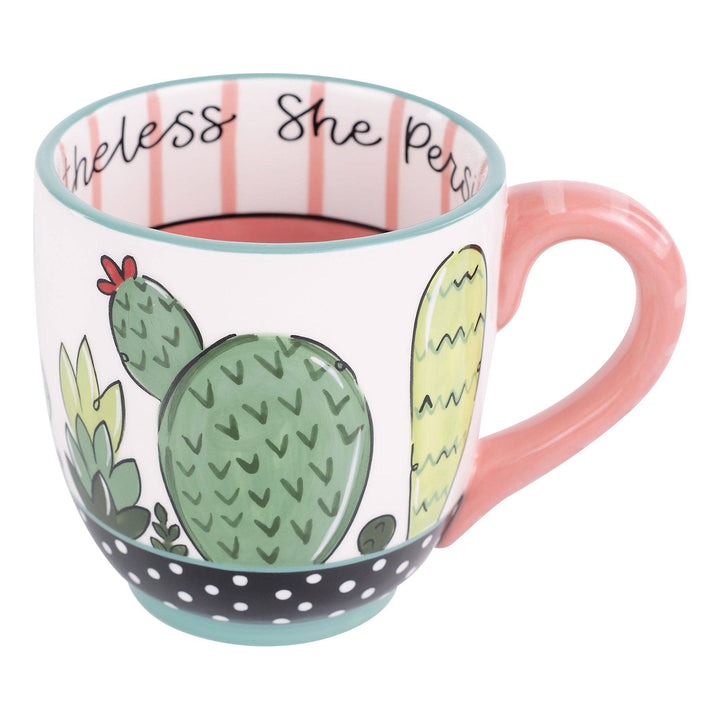 Glory Haus Nevertheless She Persisted ceramic coffee mug featuring a colorful, hand-painted cactus landscape design with a short pink handle.