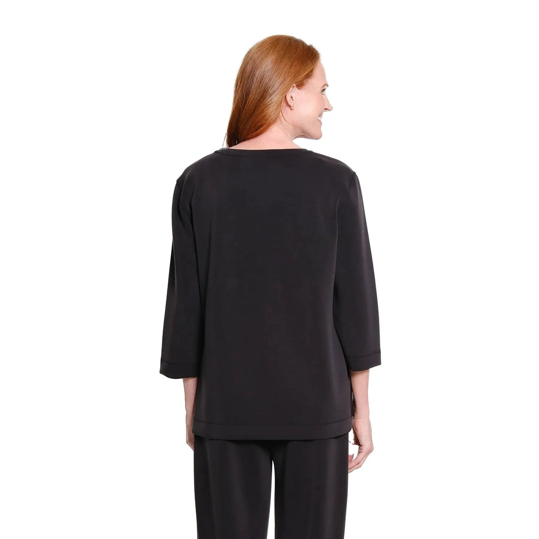 Multiples two-piece black knit set featuring a drop shoulder hi-low top and wide-leg ankle pants.