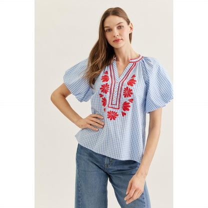 The "Tessa" Blue Plaid Top by Entro featuring red floral embroidery and flutter sleeves.