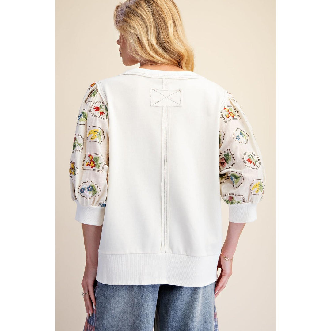 Back view of ivory terry knit top with floral embroidered sleeves