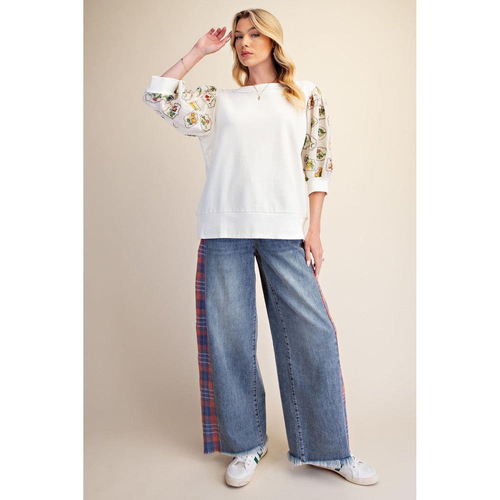 Ivory relaxed fit knit top with embroidered elbow sleeves styled with jeans