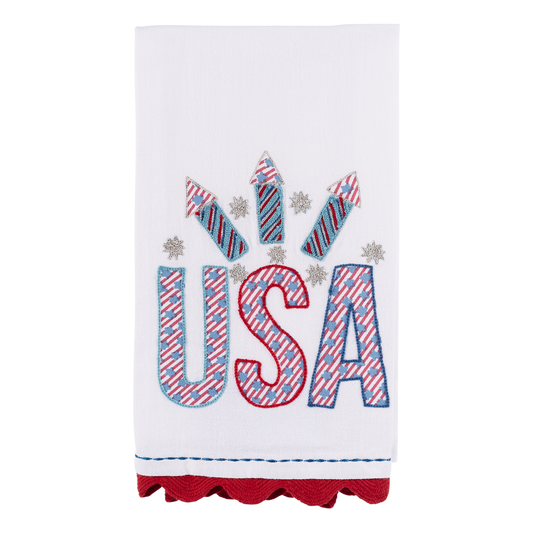 Glory Haus USA Fireworks Tea Towel showing a vibrant hand-painted illustration of red, white, and blue holiday firework rockets on a soft white kitchen towel.
