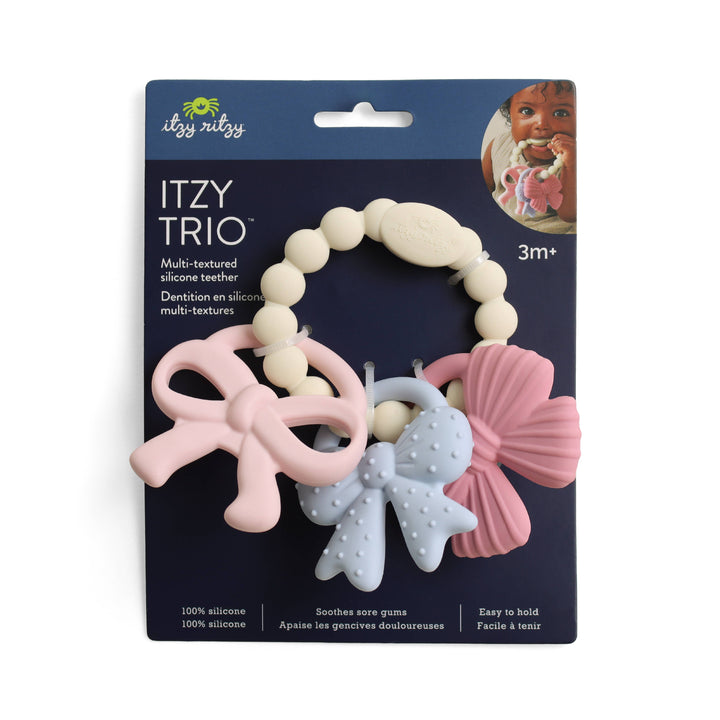 Itzy Ritzy Itzy Trio™ multicolor silicone teether in retail packaging, featuring three textured teething charms in pink, blue, and cream for sensory play