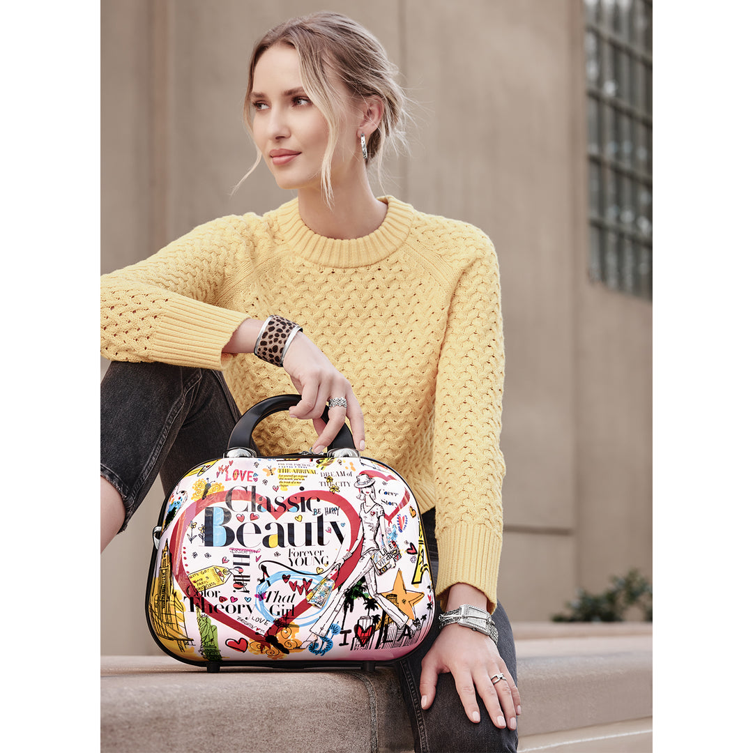 Brighton Headlines Cosmetic Case featuring a hard-shell exterior with multi-colored Fashionista headline art.