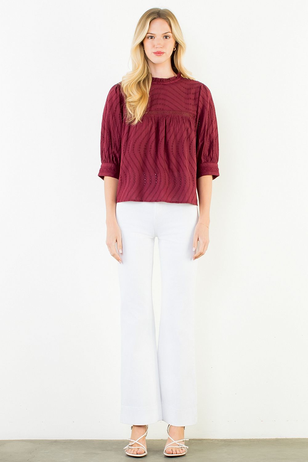 Model wearing the THML Flowy Cut Out Top in Burgundy featuring a flattering neckline detail.