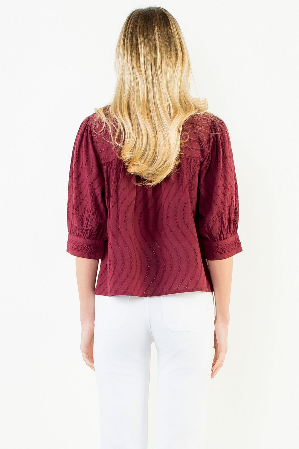 Model wearing the THML Flowy Cut Out Top in Burgundy featuring a flattering neckline detail.