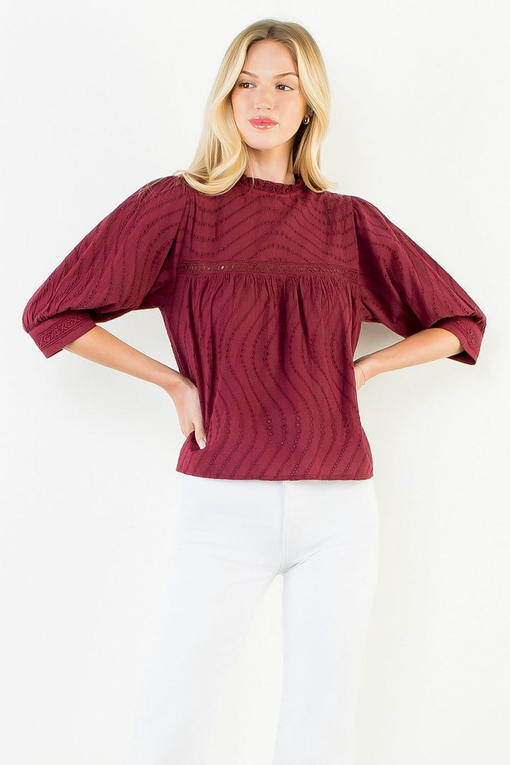 Model wearing the THML Flowy Cut Out Top in Burgundy featuring a flattering neckline detail.