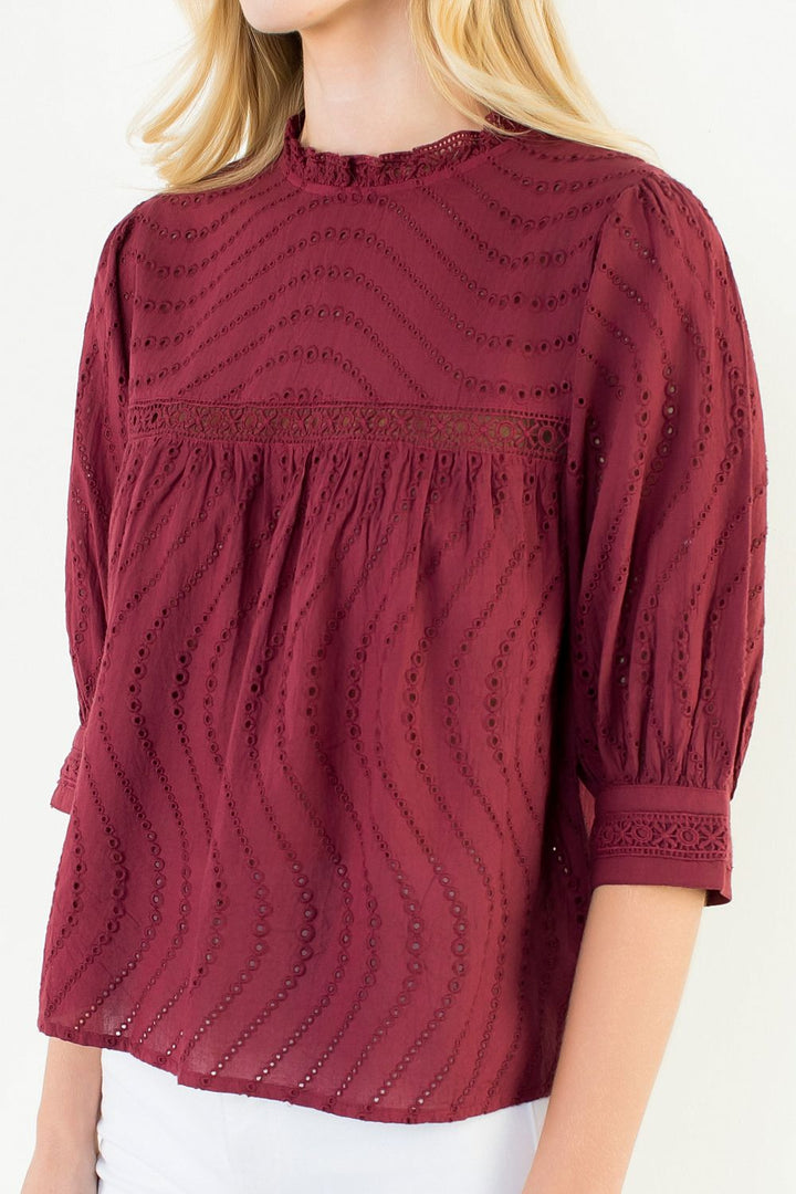Model wearing the THML Flowy Cut Out Top in Burgundy featuring a flattering neckline detail.