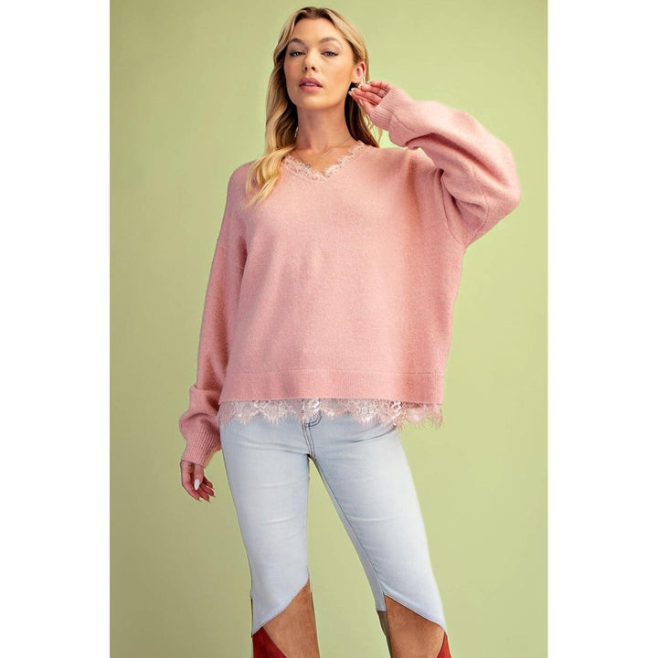 Close-up of lace hem detail on Easel coral knit sweater