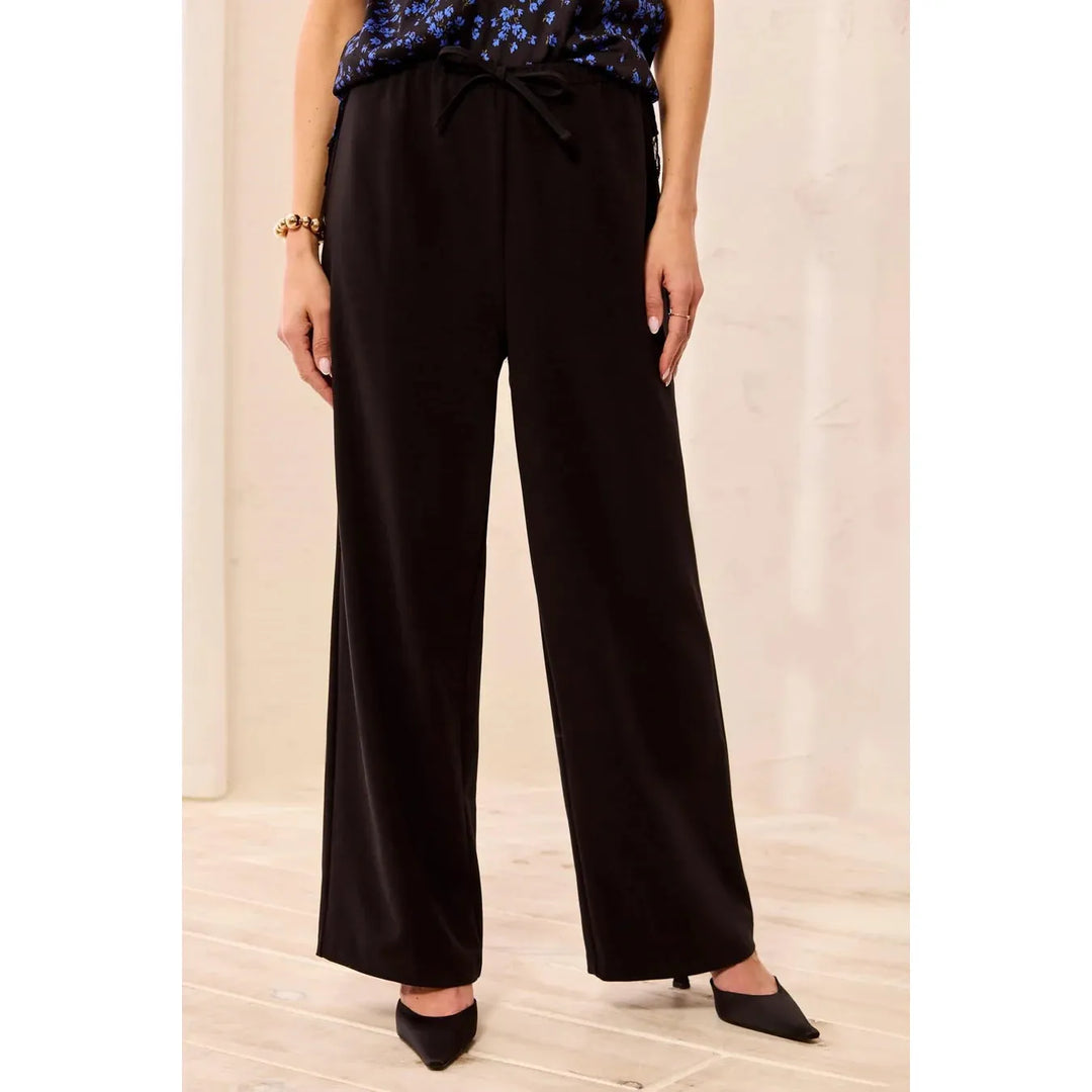 Model wearing the Tribal black flowy wide-leg pull-on pants with drawcord.
